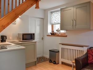 a kitchen with a sink and a microwave at Allerton House Stable in Jedburgh