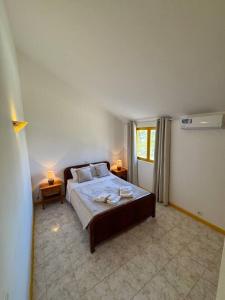 um quarto com uma cama grande e duas mesas em Murdeira V31 G by RPG Group em Beirona mais 27 fotografias