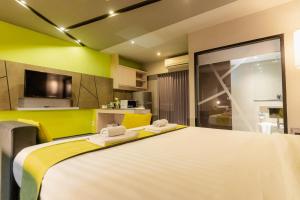 a bedroom with a large white bed with two towels at 3Season Hotel in Chiang Mai