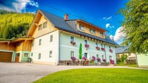 a large white building with a wooden roof at Huberbauer in Johnsbach