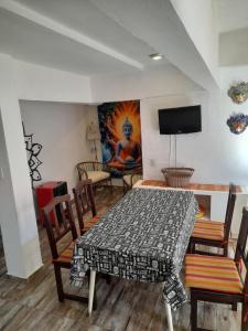a dining room with a table and chairs and a tv at El Chañar in Villa Carlos Paz