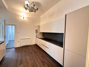 a large kitchen with white cabinets and a chandelier at Flanatika Residence Pula in Pula