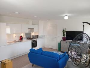 un soggiorno con un divano blu e una cucina di Detached Home in Bishopton a Bishopton