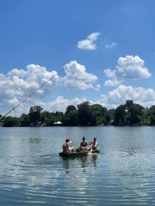 a group of people sitting in a boat on a lake at green house at silver lake in Ostrovo
