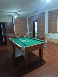 a ping pong table in a room with a couch at Pousada do Bill in Peruíbe