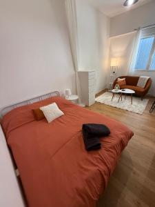 a bedroom with a large orange bed and a chair at L'Escapade Choletaise in Cholet