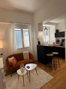 a living room with a couch and a kitchen at L'Escapade Choletaise in Cholet