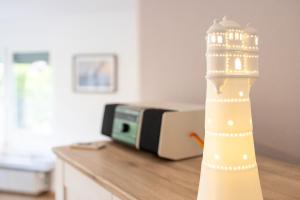 a lighthouse figurine on a counter in front of a microwave at Ferienhaus Robbenglück - Ihr Rückzugsort an der Nordsee für Familien, Gruppen und Erholungssuchende in Butjadingen OT Tossens