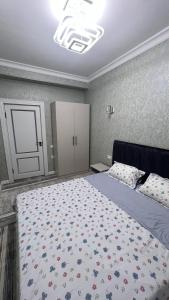 Un dormitorio con una cama grande con una colcha floral. en Квартира APPETIT, en Andiján