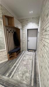 Un vestidor con una puerta y una pared de ladrillos. en Квартира APPETIT, en Andiján 4 fotos más