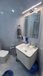 Un baño blanco con lavabo e inodoro. en Квартира APPETIT, en Andiján