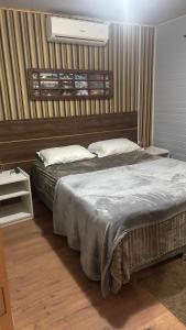 a bedroom with a large bed and a night stand at Morada da Floresta in Gramado +7 photos