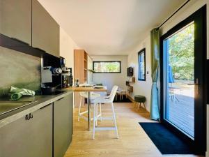 a kitchen with a counter and a table with chairs at Domaine du Mafay - LODGE BROCÉLIANDE in Bourg-des-Comptes