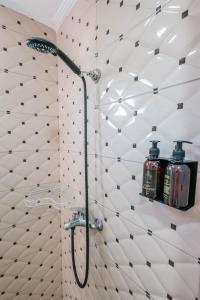 a bathroom with a shower with two bottles on a wall at Andy Apartments in Sarandë +105 photos