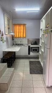 a kitchen with a white refrigerator and a table at Morada da Floresta in Gramado