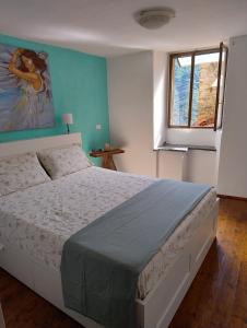 a bedroom with a large bed and a window at Antico Arco in Montalto Ligure