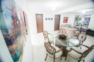 a living room with a glass table and chairs at Suites Lafragua in Veracruz