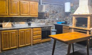 a kitchen with wooden cabinets and a wooden table at Casa Dos Avós - Alojamento Local in Bragança +22 photos