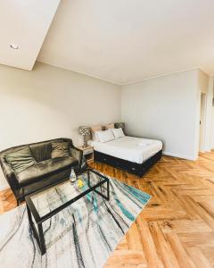 un soggiorno con un letto e un divano di Luxe Studio - On Park near Canal walk Century City a Città del Capo