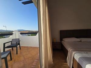 Un dormitorio con una cama y un balcón con vistas. en Elegant house with Pool and beach on foot, en Fnidek