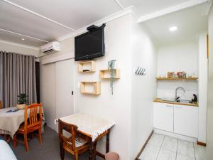 a small kitchen and dining room with a table and a tv at Eikelower Accommodation in Stellenbosch