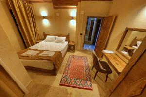 a small bedroom with a bed and a mirror at Castle Stone House in Uçhisar