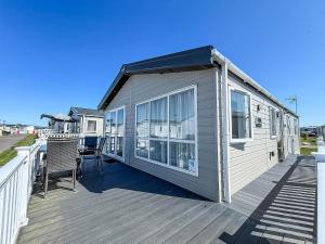 a house on a deck with a table and chairs at Stunning 3 Bedroom Lodge With Decking & Wifi In Essex Ref 44036G in Great Oakley
