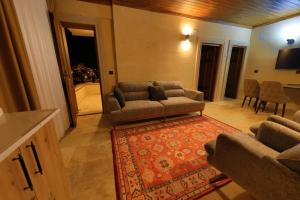 a living room with a couch and a rug at Castle Stone House in Uçhisar