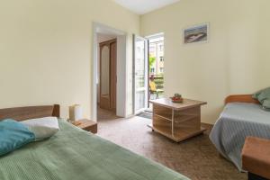 a bedroom with two beds and a door to a balcony at Ema in Palanga