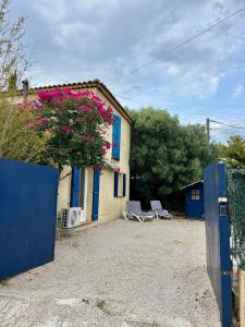 Una casa con dos sillas y una planta con flores rosas. en Charmant bas de villa avec jardin, en La Ciotat