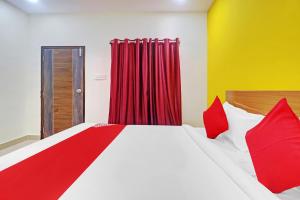 a bedroom with a bed and a red curtain at Hotel O Langar Houz Near Golconda Fort in Hyderabad +19 photos