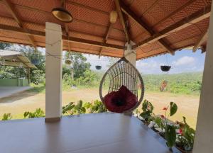 a swing on a porch with a view of a field at Thotadagadde Homestay in Mudigere