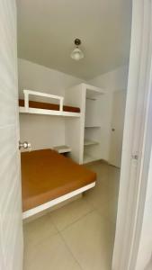 a room with a bed and shelves in it at Amplio departamento vista al mar con piscina privada en Asia Ideal para grupos y familias in Asia