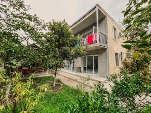 a house with a tree in front of it at Emzari's Apartment in Kobuleti