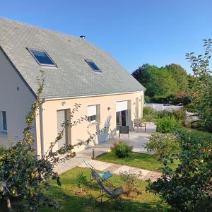 a white house with a yard with a patio at Villa le domaine du cotis in Tourlaville