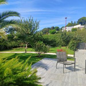 a chair sitting on a patio in a park at Villa le domaine du cotis in Tourlaville