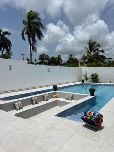 a swimming pool with a bench next to a white wall at The Jhonson villa con piscina en Las Galeras in Las Galeras