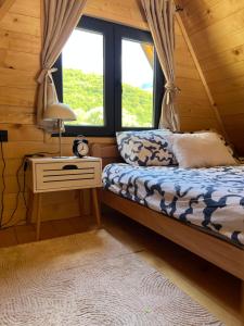 ein Schlafzimmer mit einem Bett und einer Lampe auf einem Nachttisch in der Unterkunft Vila Jezero-Jajce in Jezero