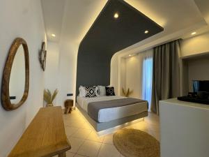 una camera con letto, specchio e tavolo di Olive Garden Hotel ad Agios Prokopios