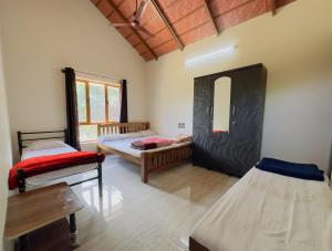 a room with two beds and a mirror at Thotadagadde Homestay in Mudigere