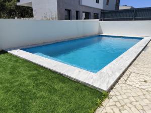 - une piscine sur le côté d'un mur blanc dans l'établissement Casa Alto das Vinhas, à Sesimbra