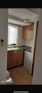 a kitchen with wooden cabinets and a white refrigerator at Casa del Mare in Ulcinj