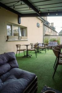an outdoor patio with chairs and a table and chairs at LOGIS -Hotel & Restaurant de la Place in Aunay-sur-Odon