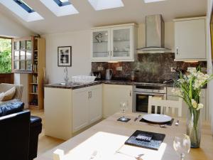 a kitchen with white cabinets and a table at Minafon in Penmaen-mawr