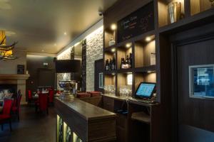 a bar in a restaurant with a laptop on a counter at LOGIS -Hotel & Restaurant de la Place in Aunay-sur-Odon