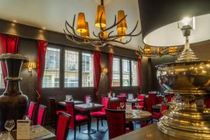 a restaurant with red chairs and tables and a chandelier at LOGIS -Hotel & Restaurant de la Place in Aunay-sur-Odon