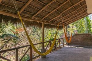 a porch with a hammock and a thatch roof at Ecosoul Bugambilia villa in Puerto Vallarta