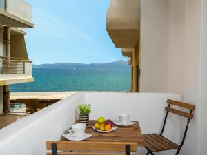 a table with a bowl of fruit on a balcony at Makas Beach Suites in Hersonissos