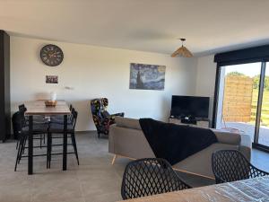 ein Wohnzimmer mit Sofa und Tisch in der Unterkunft La Vallée des Biches G2 in Saint-Martin-Boulogne