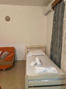 a small bedroom with a bed and a couch at Dario's Apartaments in Orikum +5 photos